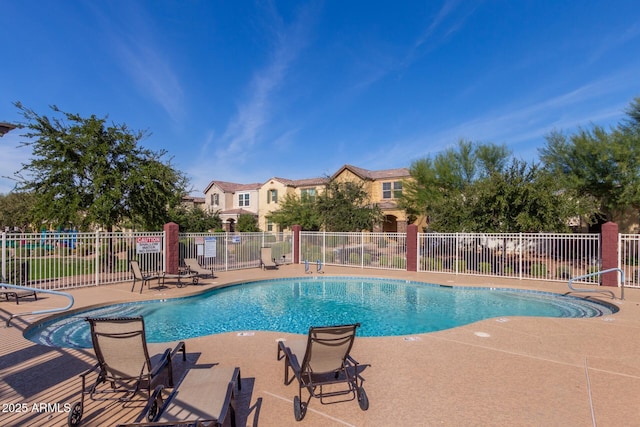 community pool with a patio and fence