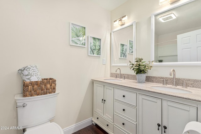 bathroom with hardwood / wood-style floors, vanity, and toilet