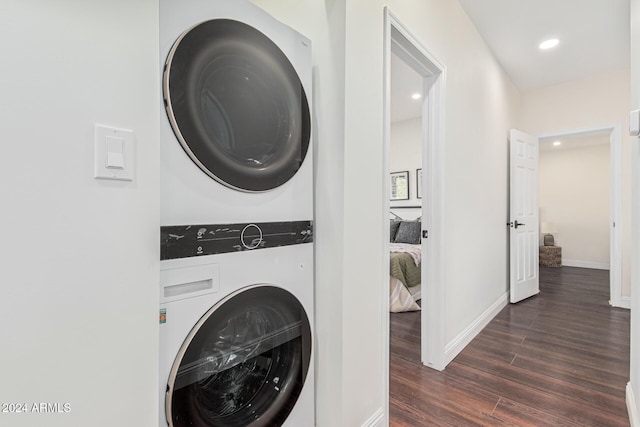 clothes washing area featuring stacked washer / dryer and dark hardwood / wood-style floors