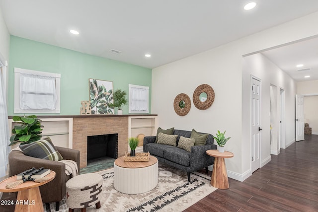 living room with dark hardwood / wood-style floors and a brick fireplace