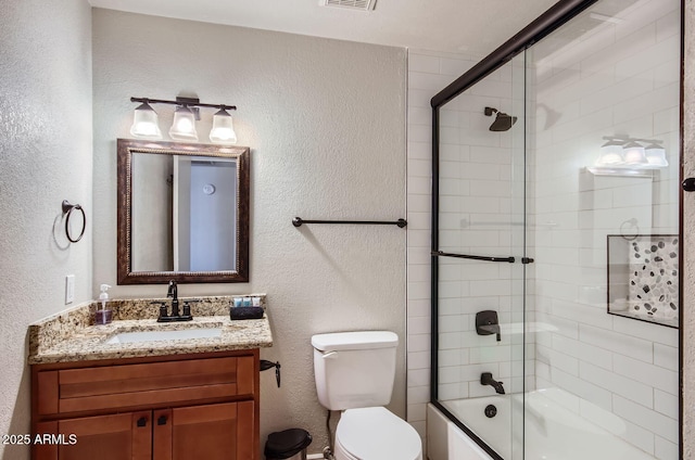 full bathroom with vanity, toilet, and shower / bath combination with glass door