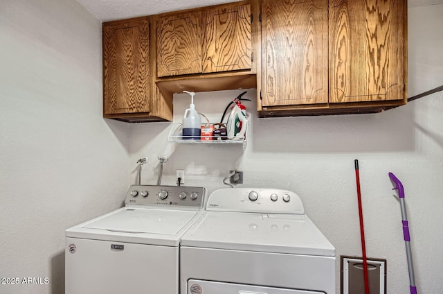 clothes washing area with washer and dryer and cabinets