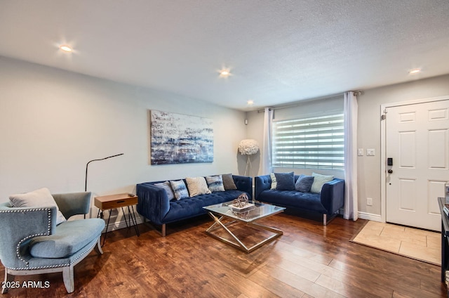 living room featuring a textured ceiling and dark wood-type flooring