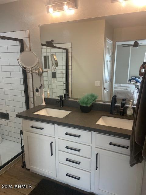 bathroom with a shower with door, vanity, and wood-type flooring