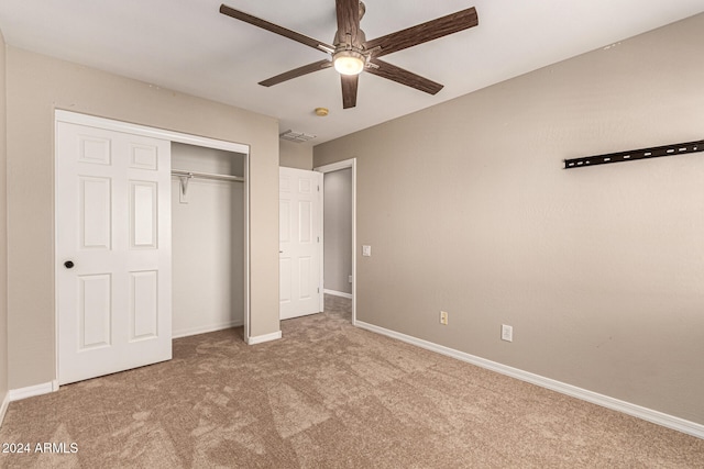 unfurnished bedroom featuring light carpet, a closet, and ceiling fan