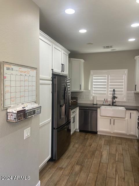 kitchen featuring tasteful backsplash, sink, dark hardwood / wood-style flooring, stainless steel appliances, and white cabinets