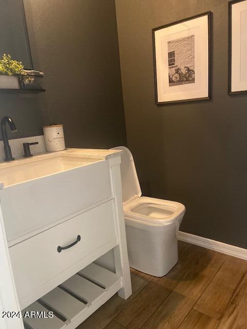 bathroom featuring vanity, toilet, and hardwood / wood-style flooring