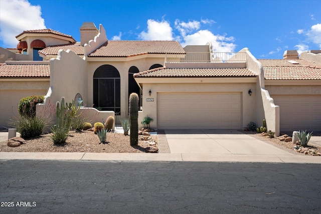 mediterranean / spanish house with stucco siding, a chimney, concrete driveway, an attached garage, and a tile roof