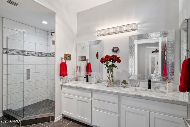 full bathroom with double vanity, visible vents, a sink, and a stall shower