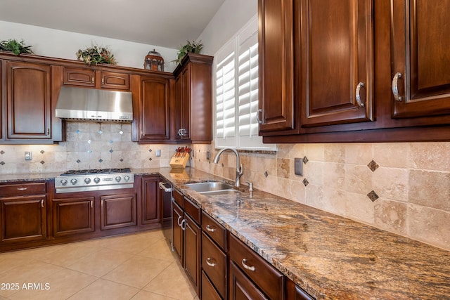 kitchen featuring ventilation hood, stainless steel gas stovetop, sink, and dark stone counters