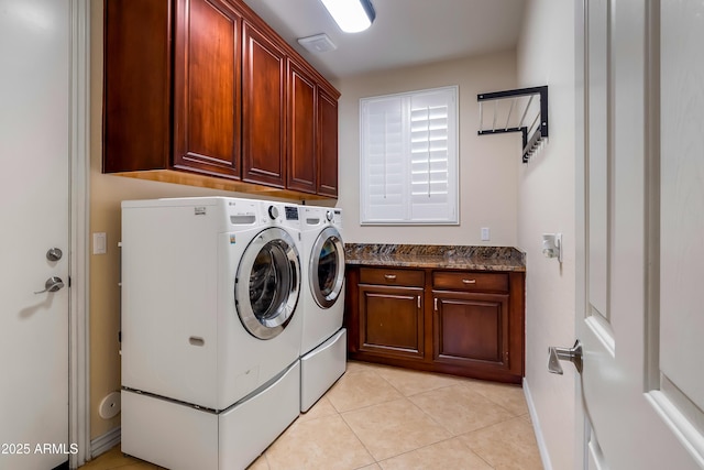 laundry area featuring cabinets, washing machine and dryer, and light tile patterned flooring