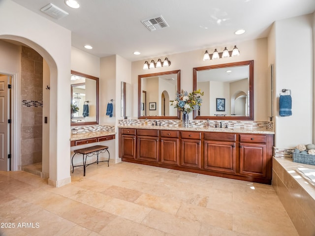 bathroom with separate shower and tub, vanity, and decorative backsplash