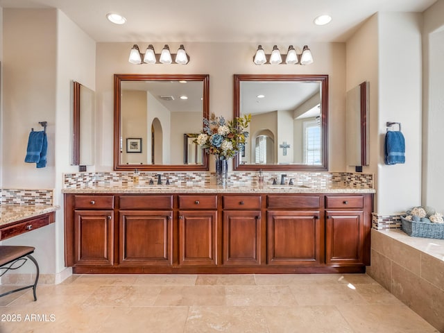 bathroom featuring vanity, a bathing tub, and tasteful backsplash