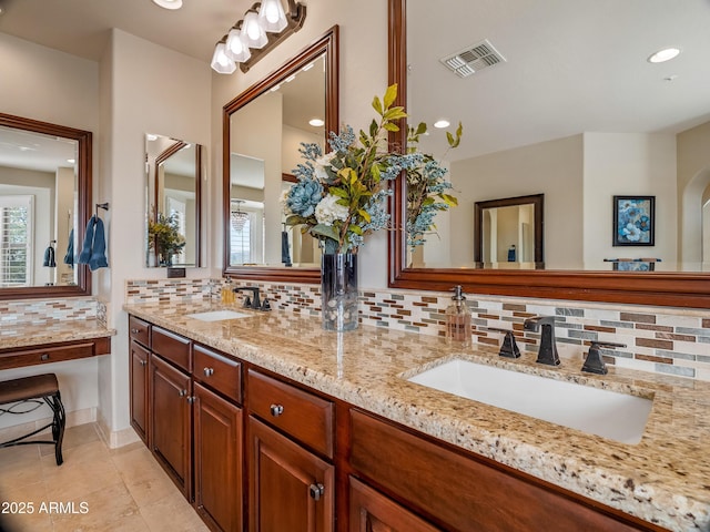 bathroom with a healthy amount of sunlight, tasteful backsplash, and vanity