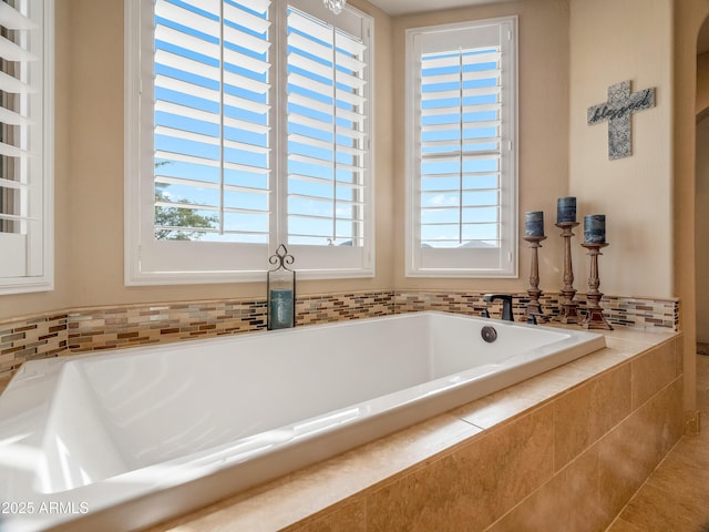 bathroom with a relaxing tiled tub