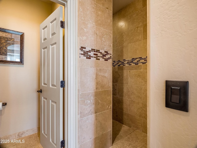 bathroom featuring tile patterned floors and a tile shower