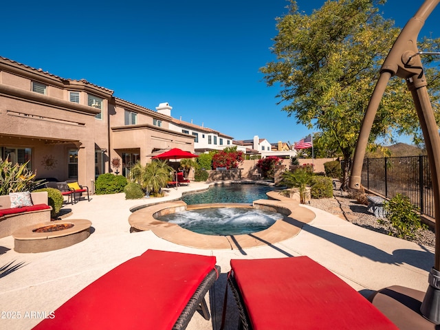 view of pool with pool water feature, a patio, a fire pit, and an in ground hot tub