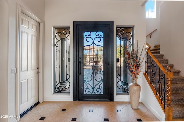 tiled entrance foyer with a healthy amount of sunlight