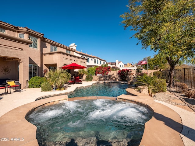 view of swimming pool with pool water feature, a patio area, and an in ground hot tub