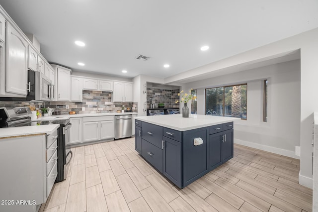 kitchen with stainless steel appliances, visible vents, light countertops, and white cabinetry