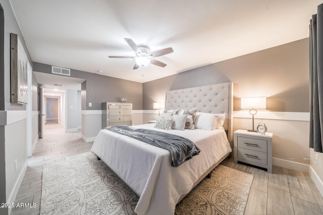 bedroom with ceiling fan, baseboards, visible vents, and wood tiled floor