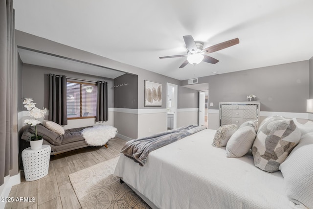 bedroom with ceiling fan, visible vents, wood finished floors, and ensuite bathroom