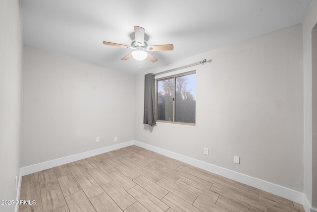 spare room with a ceiling fan, baseboards, and wood finished floors