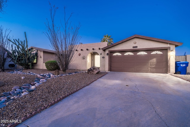 view of front of property with an attached garage, driveway, and stucco siding