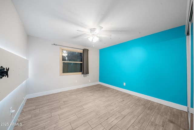 unfurnished room with baseboards, a ceiling fan, and wood finished floors