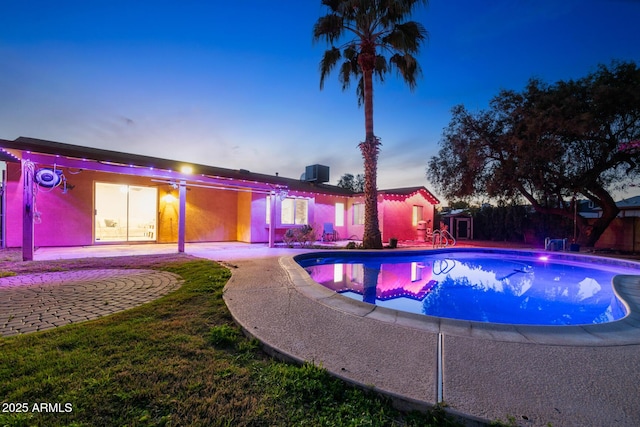 pool at dusk featuring cooling unit, a fenced in pool, and a patio area