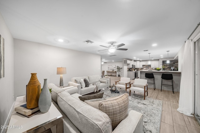 living room featuring recessed lighting, visible vents, a ceiling fan, and light wood finished floors