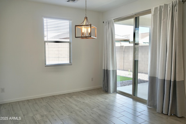 empty room with a healthy amount of sunlight, visible vents, and wood finished floors