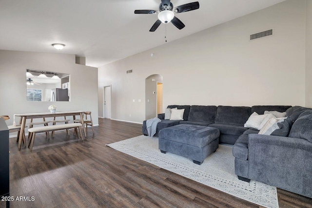 living room featuring dark wood-type flooring, ceiling fan, and lofted ceiling