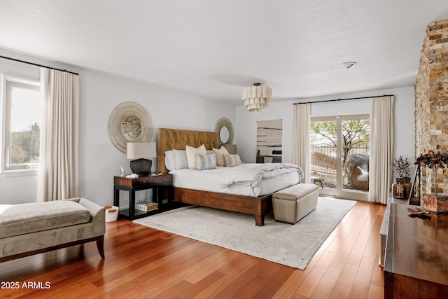 bedroom with access to exterior and hardwood / wood-style flooring