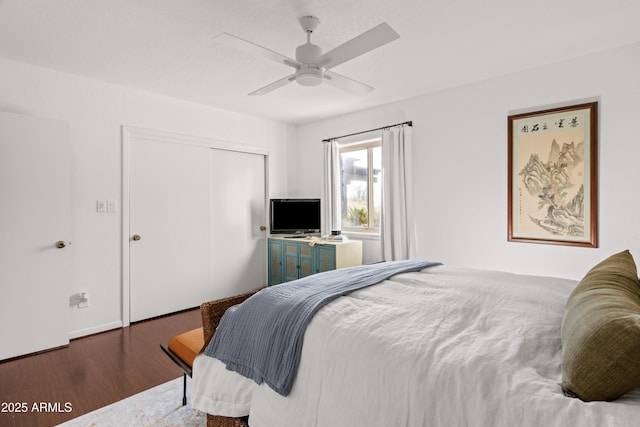 bedroom with ceiling fan, dark hardwood / wood-style flooring, and a closet