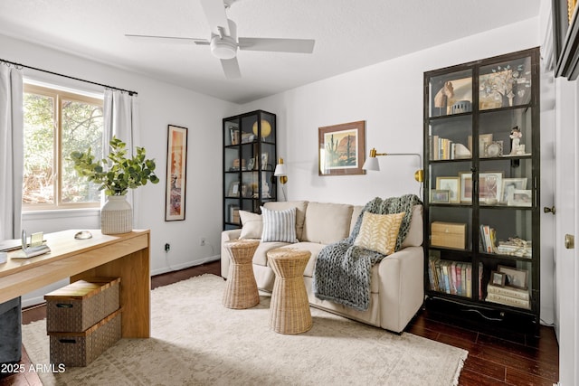 sitting room featuring dark wood-type flooring, ceiling fan, and a textured ceiling