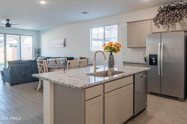 kitchen featuring a wealth of natural light, sink, an island with sink, and stainless steel appliances