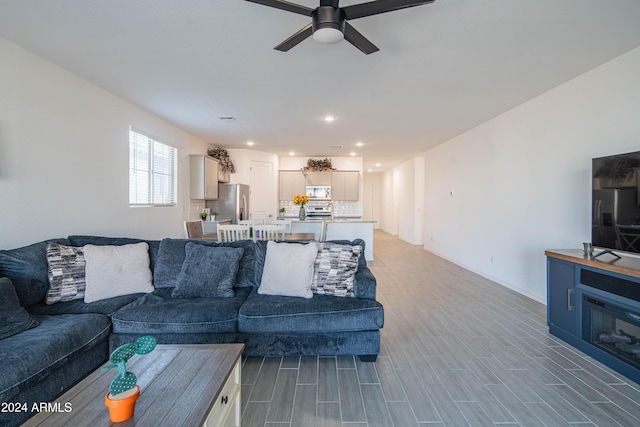 living room featuring ceiling fan and wood-type flooring