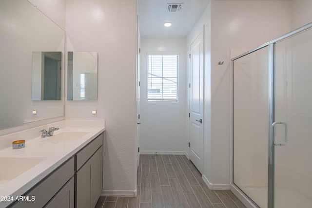 bathroom featuring vanity and a shower with shower door