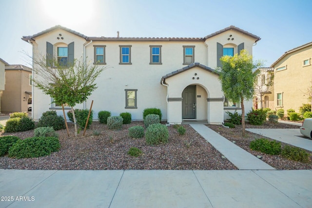 mediterranean / spanish-style house featuring stucco siding and a tile roof