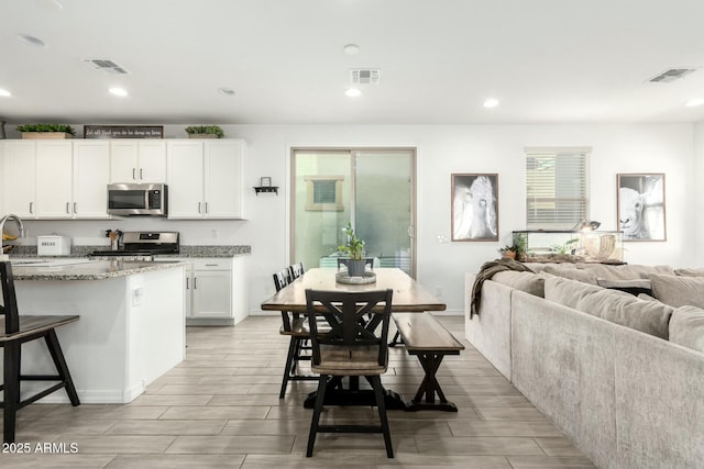 4110 S 58th Ln, Phoenix, AZ 85043 - kitchen with visible vents, light stone countertops, and appliances with stainless steel finishes