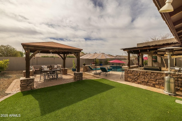 view of yard with a fenced in pool, an outdoor bar, a gazebo, a patio area, and exterior kitchen