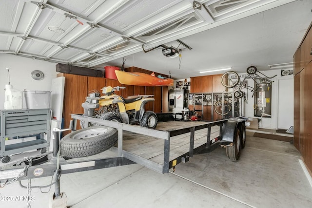 garage with a garage door opener, water heater, and a workshop area