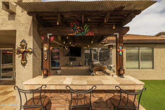 view of patio with a grill, an outdoor bar, and an outdoor kitchen