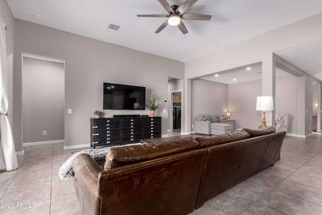 living area with light tile patterned floors, a ceiling fan, visible vents, and baseboards