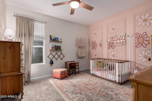 bedroom with ceiling fan, baseboards, carpet, and a nursery area