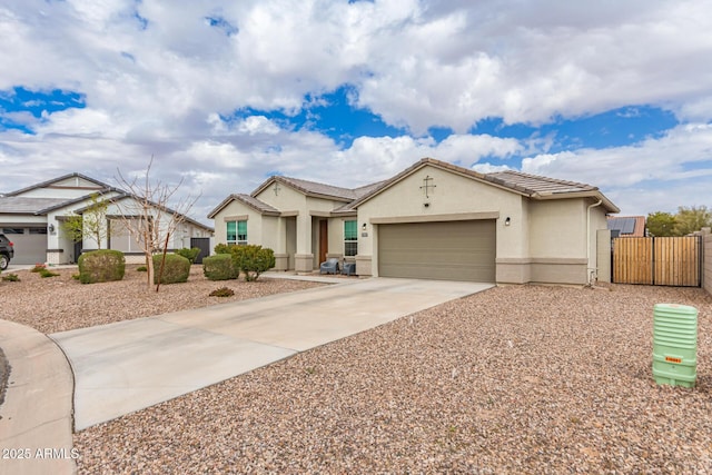 view of front facade with fence, driveway, stucco siding, a garage, and a tile roof