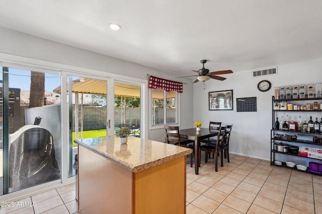 207 E Strahan Dr, Tempe, AZ 85283 - kitchen with a ceiling fan, a kitchen island, and light tile patterned flooring