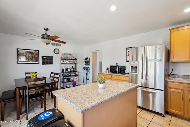 207 E Strahan Dr, Tempe, AZ 85283 - kitchen with stainless steel fridge with ice dispenser, black microwave, a center island, a ceiling fan, and light tile patterned flooring