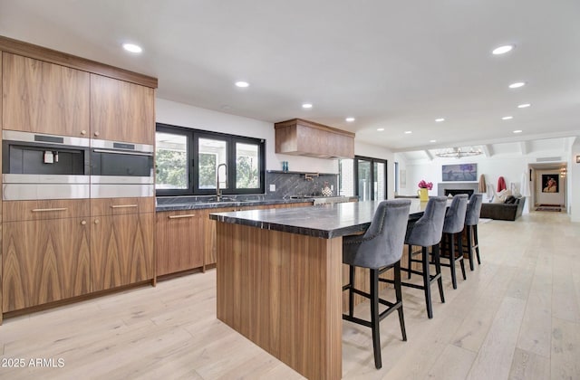 1712 E Fairfield St, Mesa, AZ 85203 - kitchen featuring light wood-style floors, recessed lighting, a kitchen bar, a spacious island, and tasteful backsplash